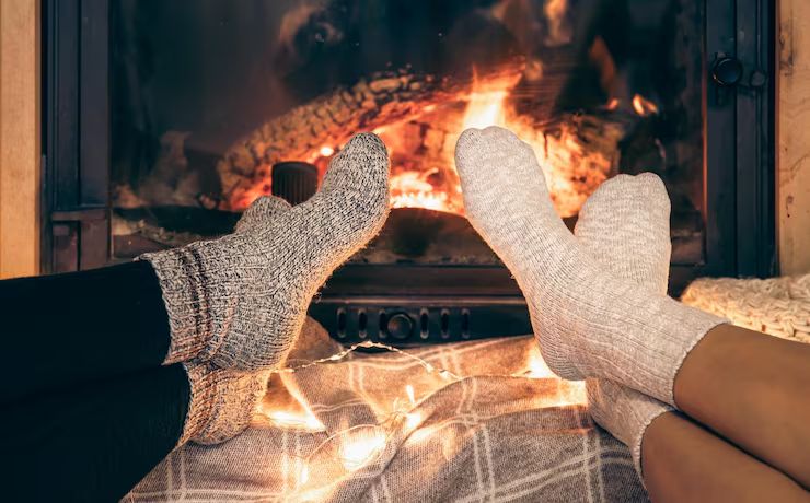 Wool socks warming in front of a glowing fireplace