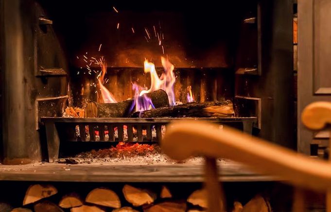 Sparks rising from burning logs in an iron fire grate