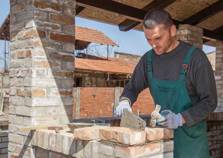 Mason laying brick on an outdoor structure